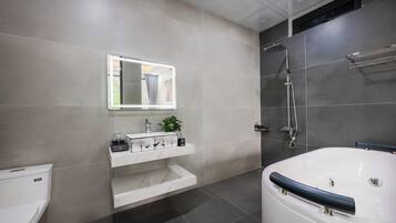 Een moderne badkamer met toilet, wastafel en bad.