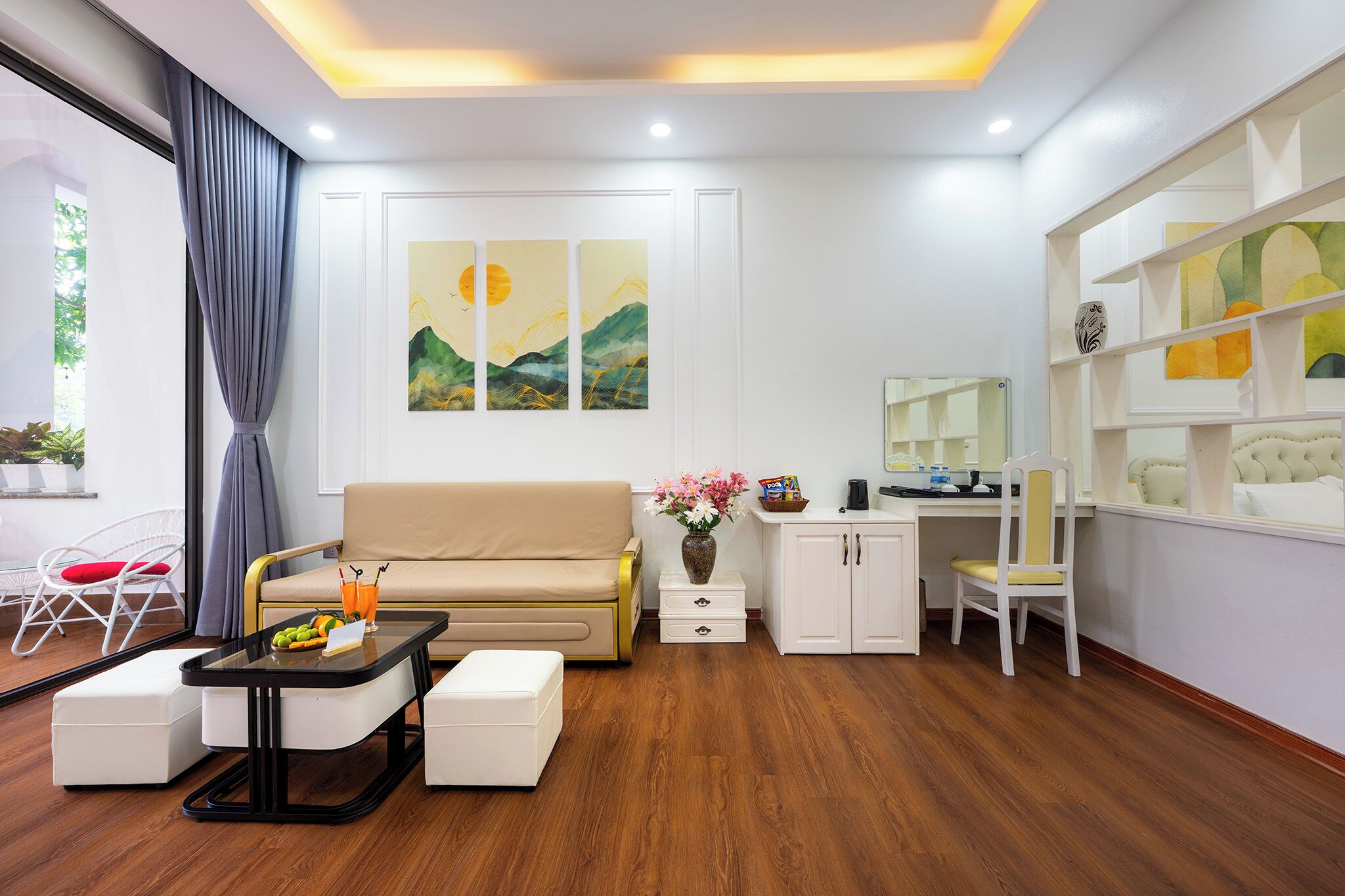 Una sala de estar moderna con un sofá, una mesa de centro y un comedor. Hay cuadros en la pared y una ventana con cortinas.