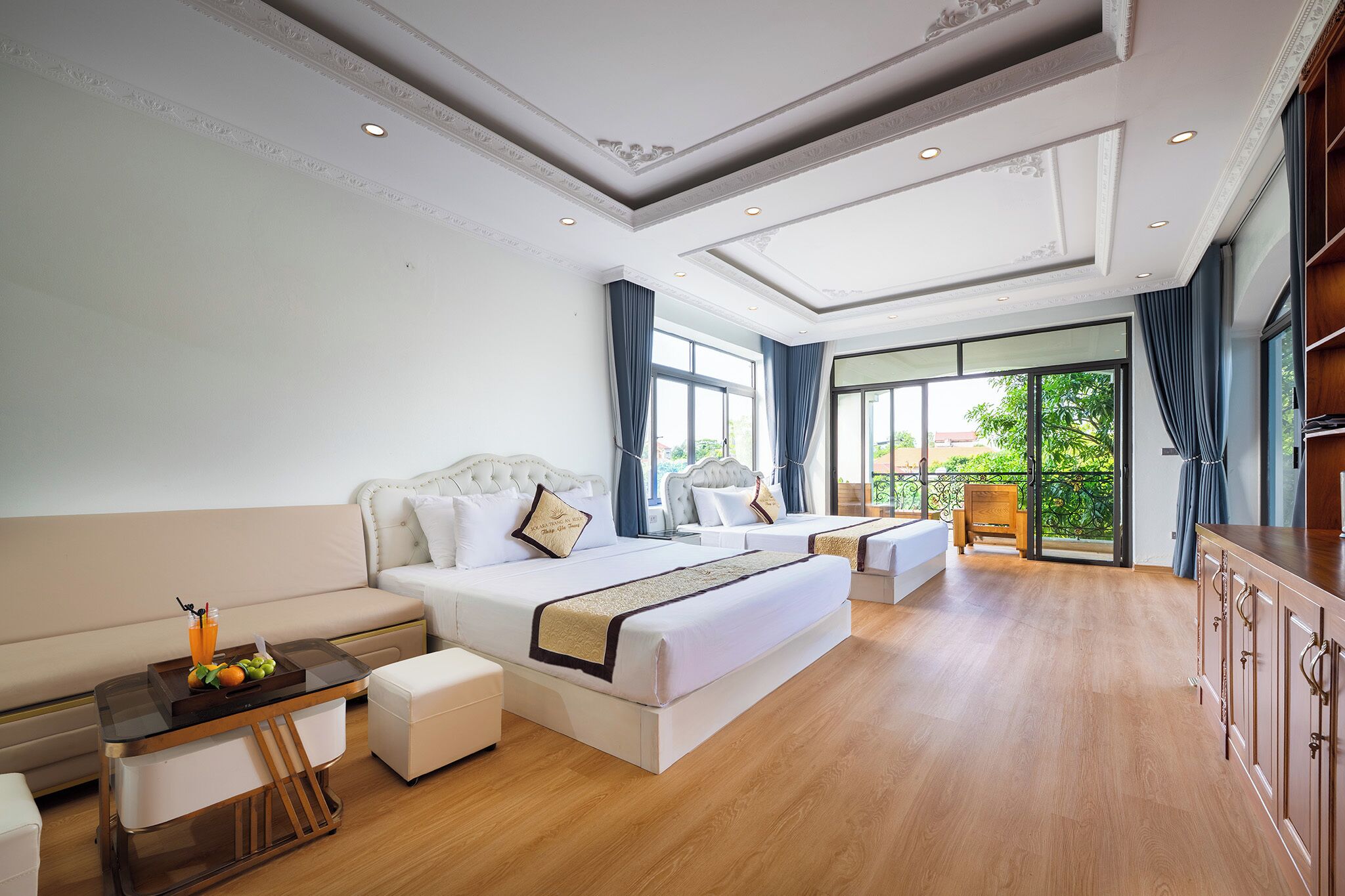 Un dormitorio amplio con una cama grande, una mesita de noche con fruta y vistas al exterior.