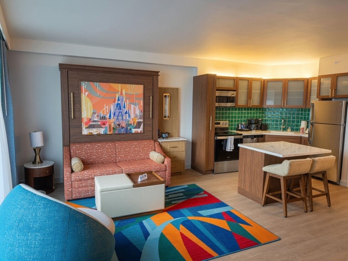 Ein stilvolles Wohnzimmer mit einer Couch, einem Couchtisch und einem farbenfrohen Teppich.