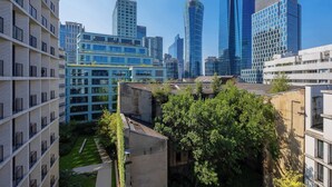 A modern urban landscape with high-rise buildings, a mix of residential and commercial architecture, and a small green space. - Stylish Apartment with Air Conditioning | Parking | Close to the City Centre (Warszawa)