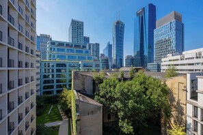 A modern urban landscape with high-rise buildings, a mix of residential and commercial architecture, and a small green space. - Stylish Apartment with Air Conditioning | Parking | Close to the City Centre (Warszawa)