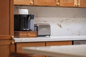 Eine Küche mit Kaffeemaschine, Toaster und Holzschränken.