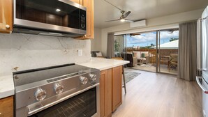 A modern kitchen with a built-in oven, microwave, and a large island.