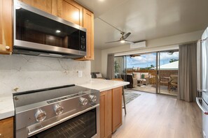 A modern kitchen with a built-in oven, microwave, and a large island.