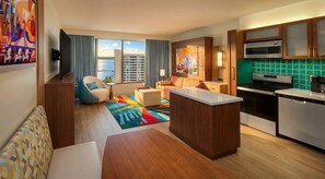 Ein modernes Hotelzimmer mit Küche, Essbereich und Wohnbereich.