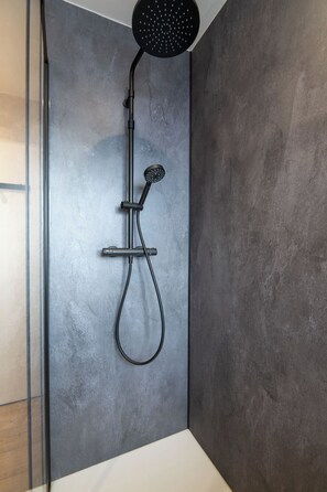 A modern shower with a handheld showerhead and a wall-mounted control. - K1 – View of the slopes & panoramic terrace (Gérardmer)