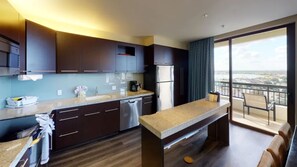 Una cocina moderna con armarios oscuros, un lavavajillas de acero inoxidable y una isla grande.