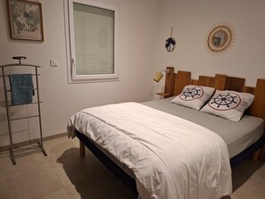 A bedroom with a bed, a towel rack, a window, and wall decorations. - Family home near the beaches. Pets welcome! (Assérac)