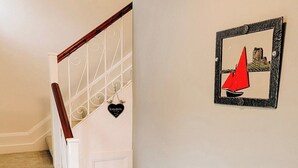 A staircase with a white handrail and a patterned floor.