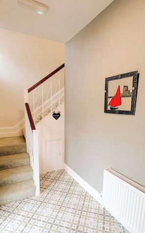 A staircase with a white handrail and a patterned floor.