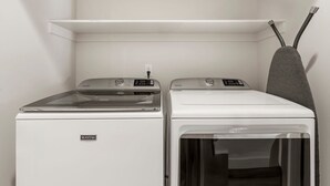 Een wasserette met twee Maytag wasmachines en een droogrek.