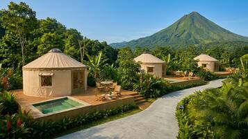 A resort with yurts, a swimming pool, and a mountain view.