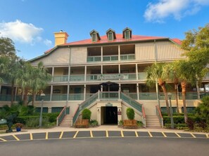 A multi-story hotel with a red roof, balconies, and a sign reading 'Live Out Here.' - Hilton Head | Couples Island Retreat | Pool + Beach (Hilton Head Island)