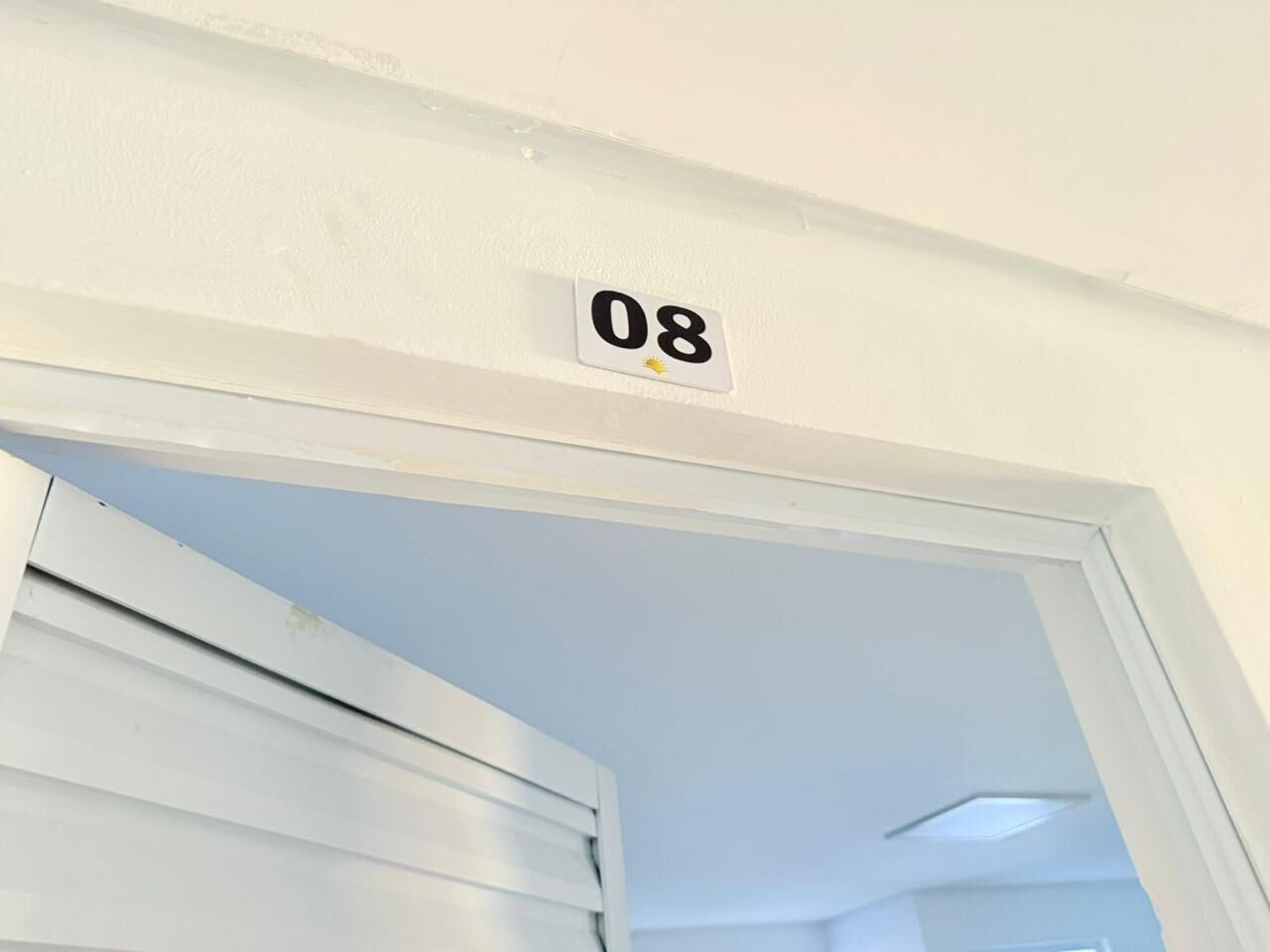 Uma porta branca com uma placa com o número 08 acima.