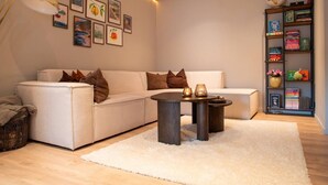 A modern living room with a sofa, a coffee table, and a bookshelf. - North Nest Signature Apartment (Tromsø)