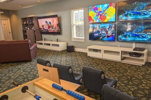 A living room with a sofa, a TV, and a table with weights. - Orlando | Relaxed Disney Escape | Pool + Walkable BoardWalk (Lake Buena Vista)
