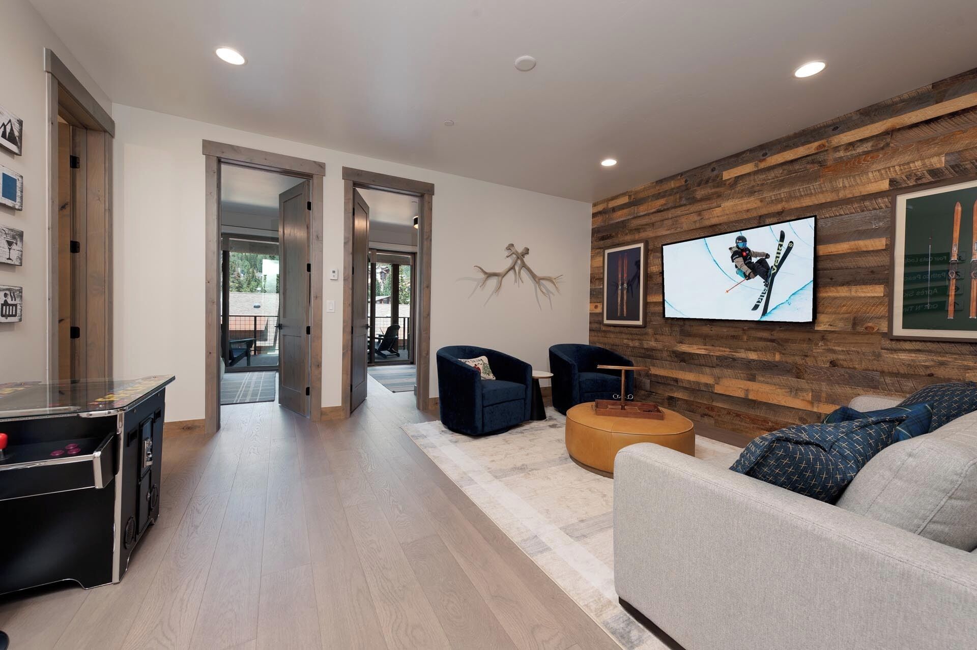 Un intérieur moderne avec un mur d’accent en bois, un téléviseur et un coin salon doté d’une table basse.