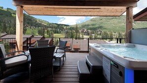 A wooden deck with outdoor seating and a hot tub, overlooking a mountainous landscape. - Brand New Townhome Across from Purg - Hot Tub/Arcade Game/Views/EV Charger (Durango)