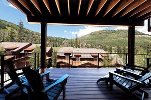 A wooden deck with chairs and tables, overlooking a mountainous landscape with buildings. - Brand New Townhome Across from Purg - Hot Tub/Arcade Game/Views/EV Charger/AC (Durango)