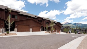 A modern multi-story building with a garage, a driveway, and a mountain view. - Brand New Townhome Across from Purg - Hot Tub/Arcade Game/Views/EV Charger (Durango)