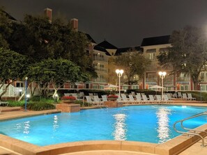 A swimming pool with lounge chairs and a lighted pathway. - Orlando | Lively BoardWalk Escape | Pool + Walkable Dining (Lake Buena Vista)