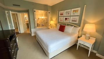 Una camera d'albergo con un letto grande, comodini, un armadio e un bagno visibile tramite una porta aperta.