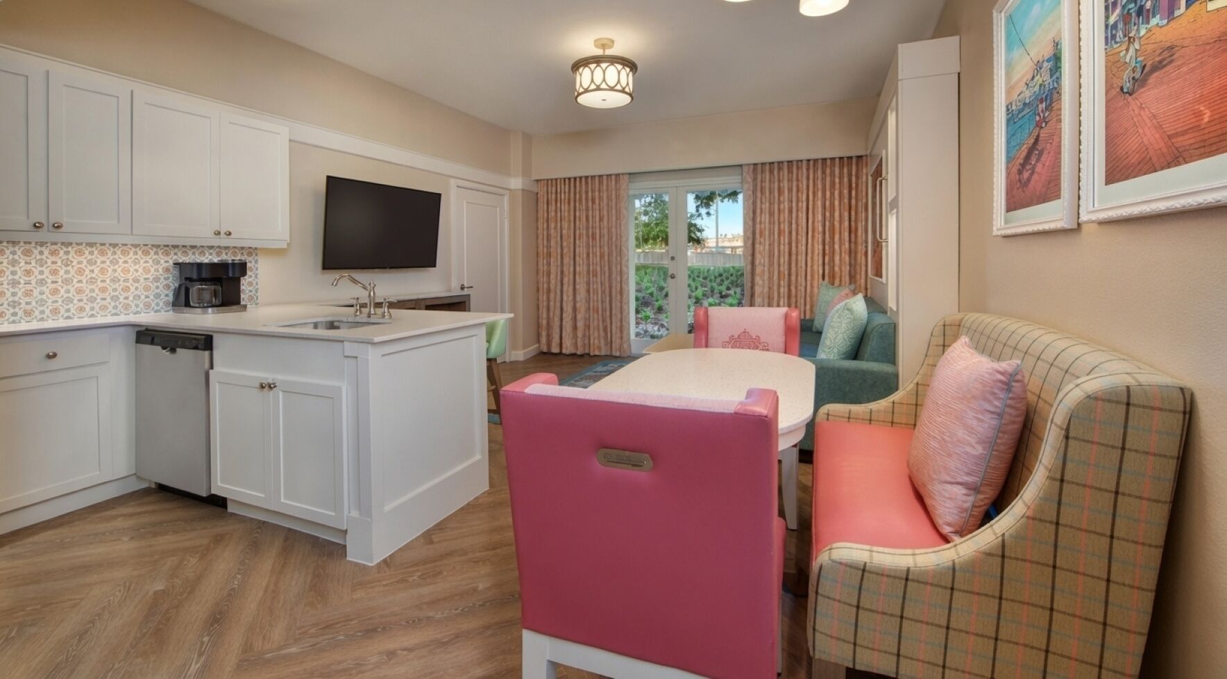 A compact living space with a kitchenette, a dining area, and a seating area with a sofa and a chair.