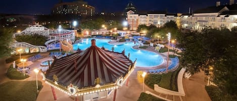 A nighttime view of a resort with a swimming pool, a carousel, and a building labeled 'Family Amusement.'