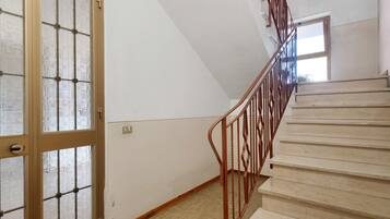 Eine Treppe mit Holzwertlauf und gefliestem Boden.