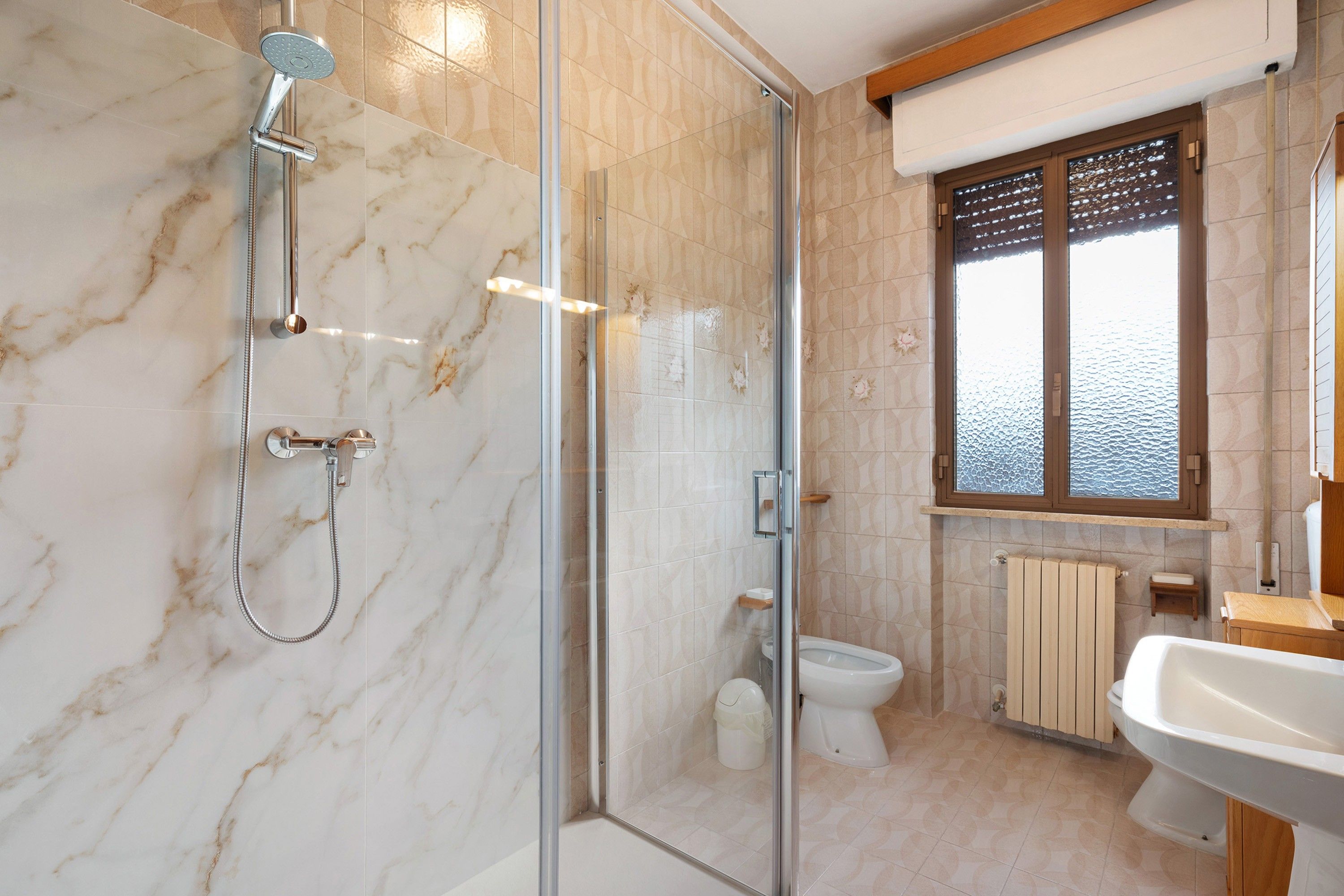 Une salle de bain moderne avec une douche à parois de verre, des toilettes et un lavabo.