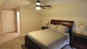 A bedroom with a bed, nightstands, a ceiling fan, and a door. - Spacious 4-bedroom house in Franklin Kentucky (Franklin)