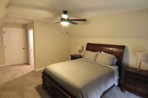 A bedroom with a bed, nightstands, a ceiling fan, and a door. - Spacious 4-bedroom house in Franklin Kentucky (Franklin)