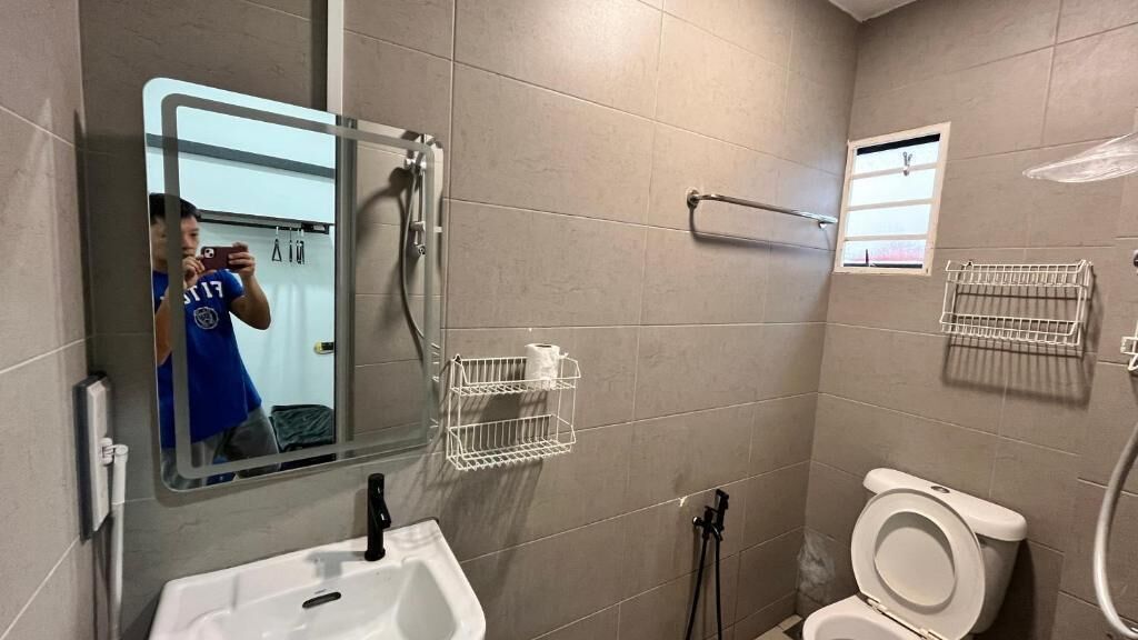 A bathroom with a sink, toilet, mirror, and towel racks.