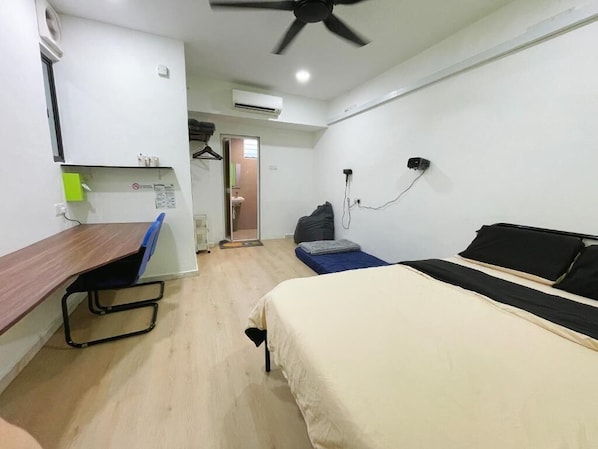 A compact hotel room with a bed, a desk, and a ceiling fan. - D Cloud Homestay & Room (Kajang)