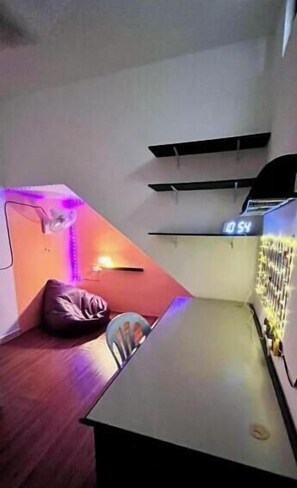 A room with a bed, a table, and a wall-mounted air conditioning unit.