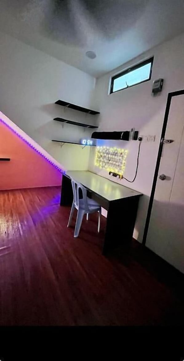 A room with a desk, chair, and a window.