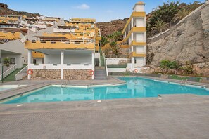 A swimming pool area with a building in the background.