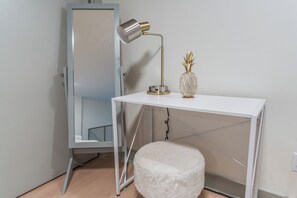 A white desk with a lamp and a pineapple-shaped vase, a white ottoman, and a metal-framed wardrobe. - Designer Loft - Parking Nearby Hospitals - 2F (Louisville)