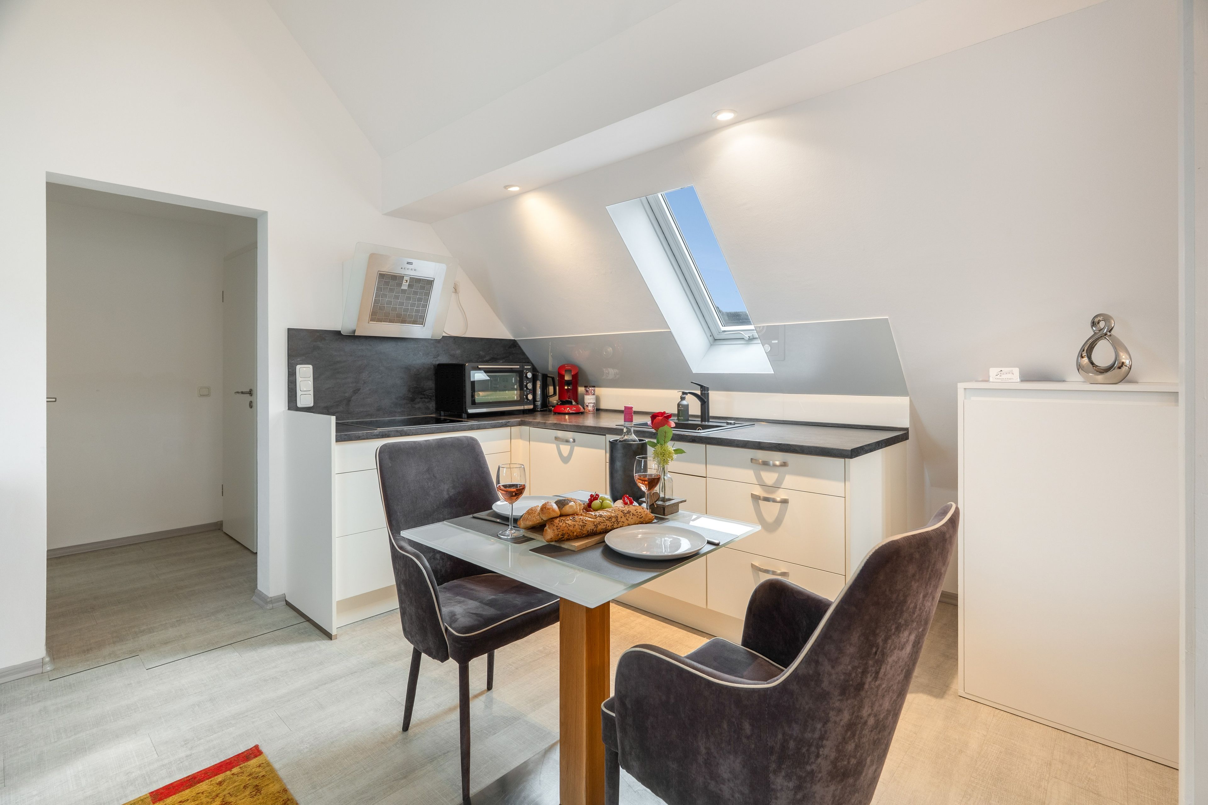 A compact kitchen with a dining area, a built-in microwave, and a small window.