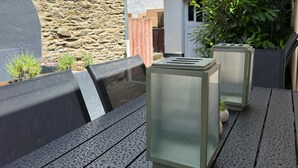 An outdoor seating area with a stone wall, a wooden fence, and a potted plant. - Vetera Apartment with Mountain View, Private Terrace & Wi-Fi (Bendorf)