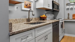 A kitchen with a granite countertop, stainless steel appliances, and white cabinetry. - Serene Villa Steps From Beach w/ Pool and Tennis! (Hilton Head Island)