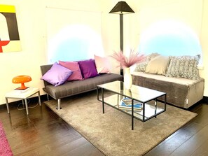 A living room with a sofa, two side tables, a floor lamp, and a glass coffee table. - Charming two-story apartment located a 15-minute walk from St. Peter's (Roma)