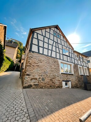 A traditional half-timbered house with stone walls and a paved driveway. - Apartment 'Ferienwohnung Kleinôd' with Private Terrace and Wi-Fi (Bendorf)