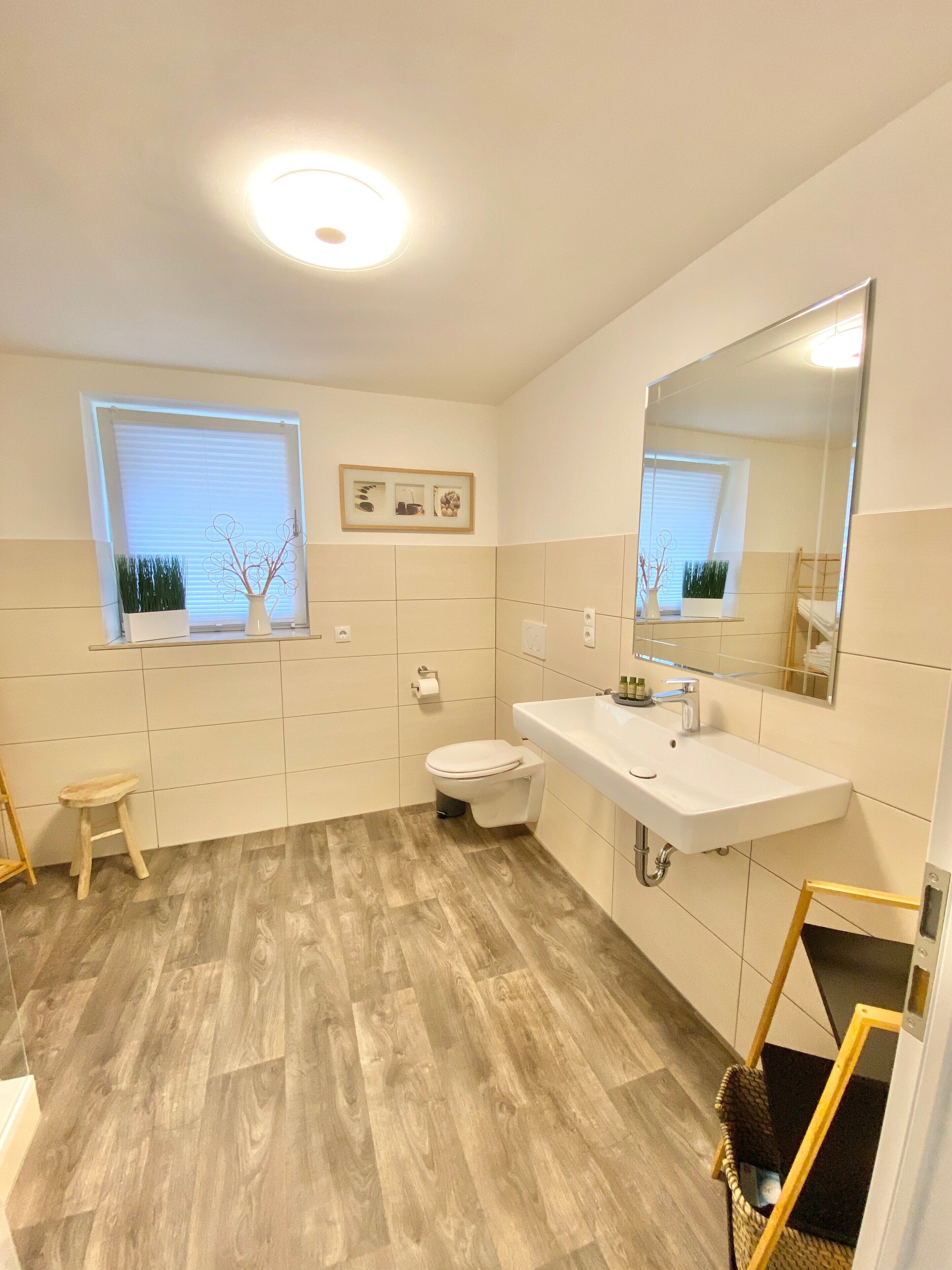 Une salle de bain moderne avec des toilettes, un lavabo et une fenêtre.