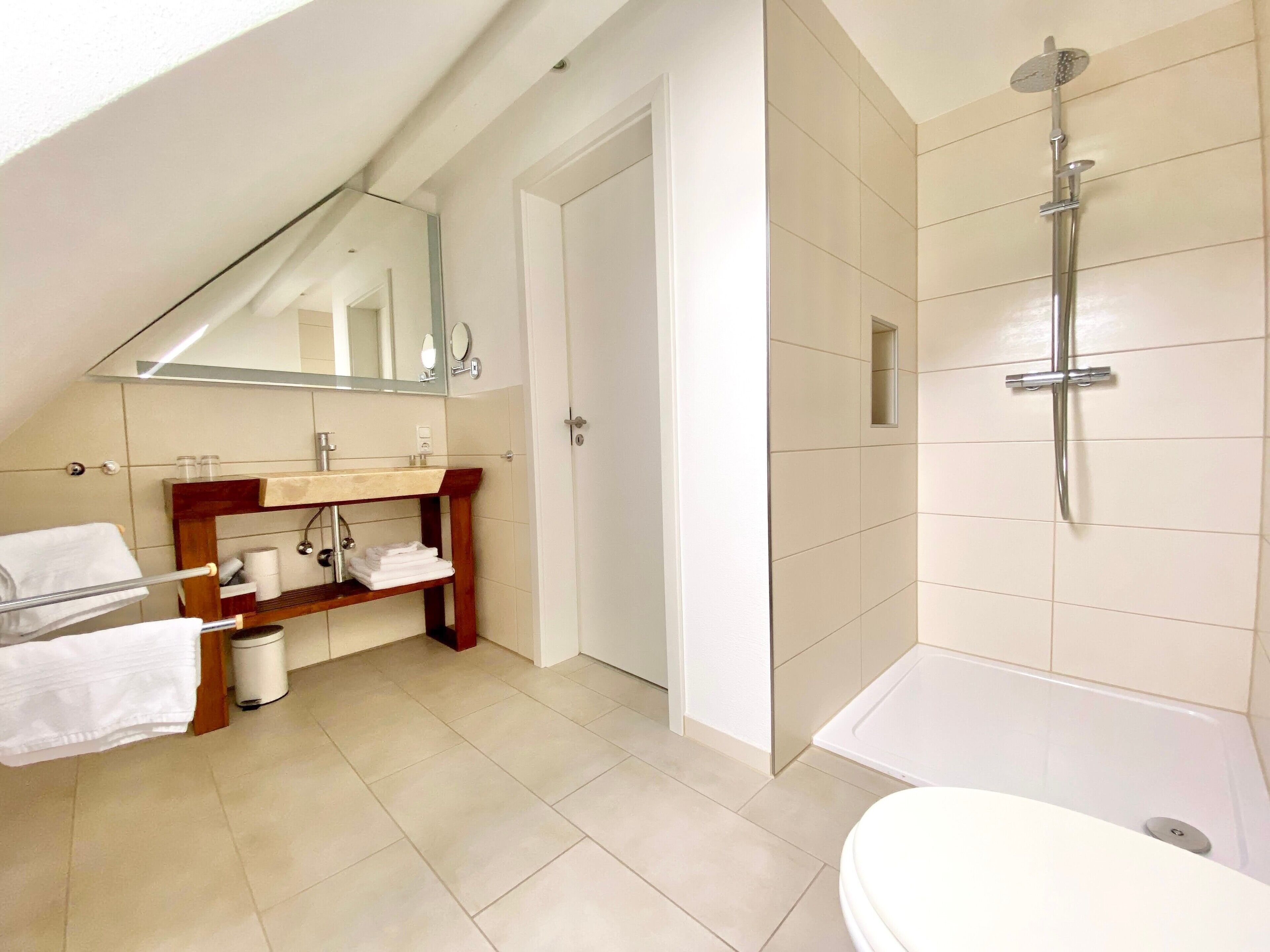 Ein modernes Badezimmer mit Dusche, Toilette und Waschtisch.