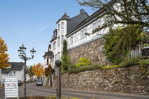 Un bâtiment historique doté d’un mur en pierre et d’une façade traditionnelle à pans de bois.