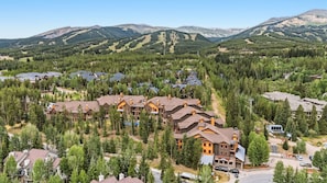 A resort with multiple buildings surrounded by dense forest and mountains. - Luxury Mountain Escape | Steps to Snowflake Lift with Resort Amenities (Breckenridge)