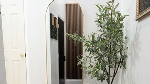 Ein Flur mit Blumentopf, Spiegel und ornamentierten Bodenfliesen.