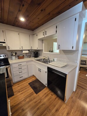 A modern kitchen with white cabinets, stainless steel appliances, and a wooden floor. - 3-bedroom Chassahowitzka River, by campground, pet friendly
Manatee retreat (Homosassa)
